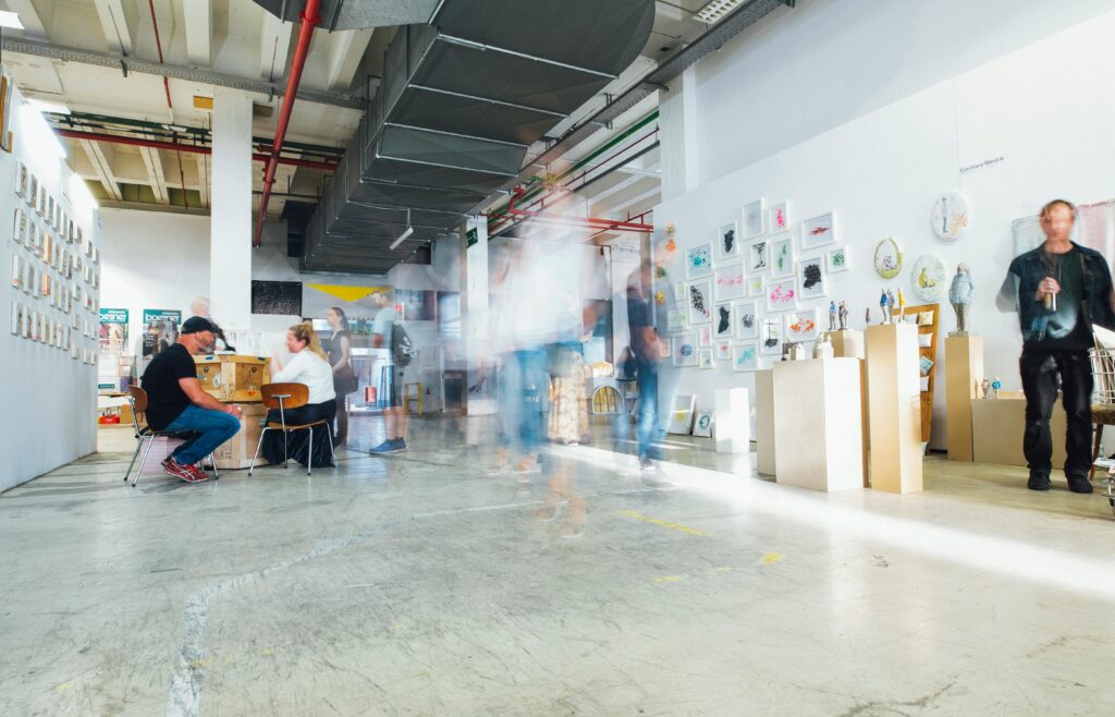 pexels-photo-2559739-2559739 Blurred motion of visitors in a modern art gallery displaying various artworks.